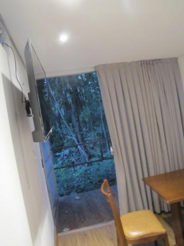 a door in a room with a table and a chair at Econtainer Suítes Macacos in Macacos