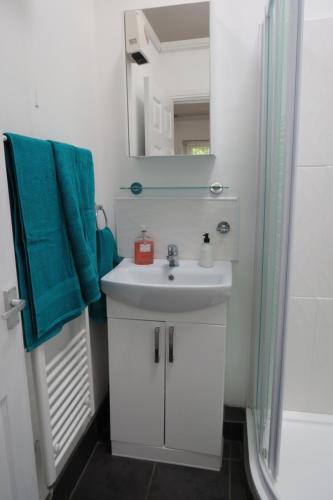 a bathroom with a sink and a mirror at The Old Stables, Whitehall Farmhouse, Oakington in Cambridge