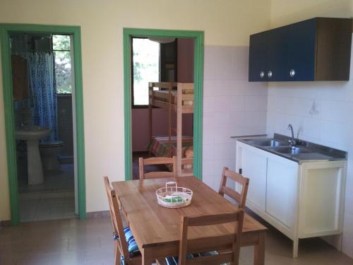 a kitchen with a wooden table with chairs and a sink at Agriturismo Tenuta La Siesta in Gallipoli