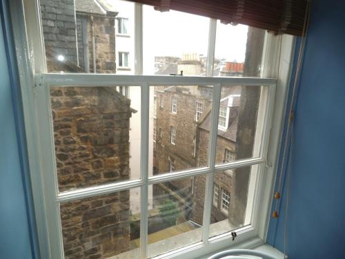 une fenêtre avec vue sur un bâtiment en briques dans l'établissement Royal Mile Apartment, à Édimbourg