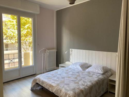 une chambre avec un lit et une grande fenêtre dans l'établissement L Europe Arcachon, à Arcachon