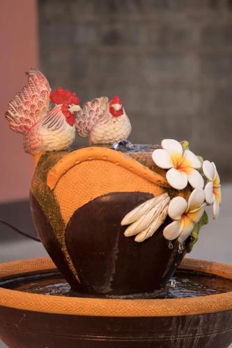 a vase with two chickens sitting on top of it at Lomluang hostel&hotel in Nan