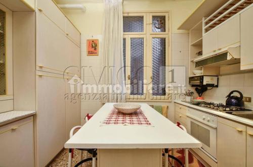 a white kitchen with a table and a window at Apartment Odesos in Venice