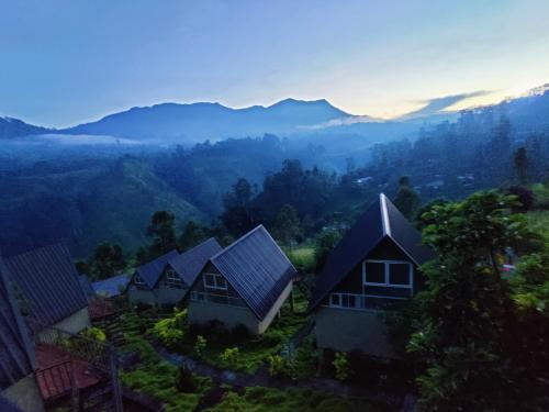 een groep huizen op een heuvel met bergen op de achtergrond bij St.Clair Villas in Dimbula