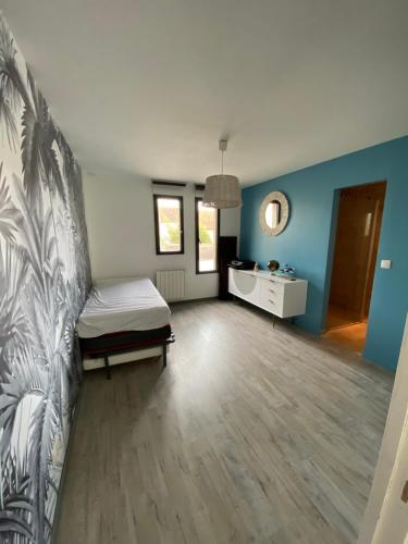 a bedroom with a bed and blue walls at Belle villa contemporaine & lumineuse plage normandie in Luc-sur-Mer