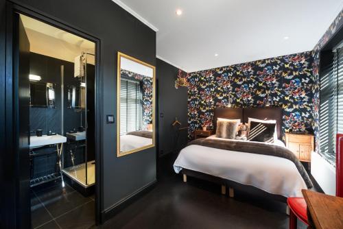 a bedroom with a large bed and a bathroom at La Goélette, Chambres d'Hôtes in Wimereux