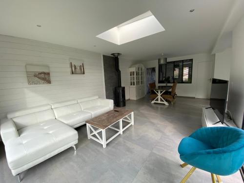 un salon avec un canapé blanc et une table dans l'établissement Belle villa contemporaine & lumineuse plage normandie, à Luc-sur-Mer