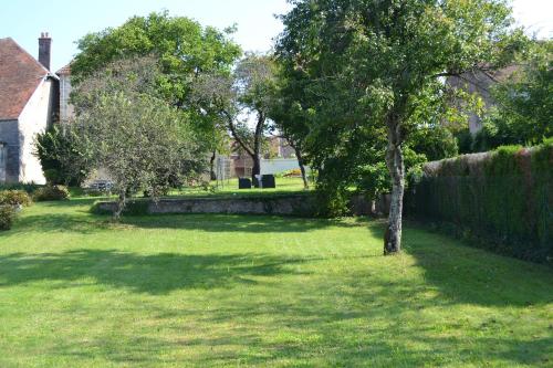 a yard with a tree and a fence at Chambres d'Hôtes Le Moulin à Epices in Chargey-lès-Gray