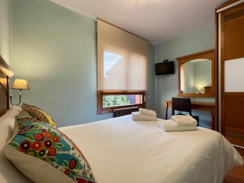 1 dormitorio con cama blanca y espejo en Hostal Restaurante Torreblanca, en Duruelo de la Sierra