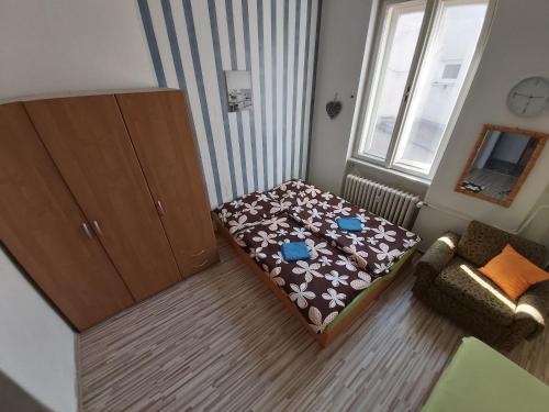 a small living room with a bed and a cabinet at Easy Backpacker Old Town in Košice