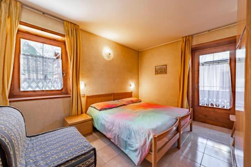 a small bedroom with a bed and a chair at Chalet La Nuvola in Livigno