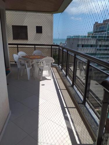 een balkon met een tafel en stoelen in een gebouw bij Apartamento na Enseada com vista para o mar - 300 m da praia in Guarujá