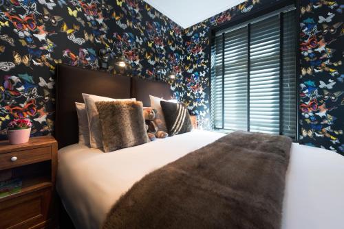 a bedroom with a large bed with floral wallpaper at La Goélette, Chambres d'Hôtes in Wimereux