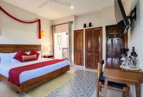 a bedroom with a bed and a desk in it at Le Muuch Hotel Boutique in Valladolid