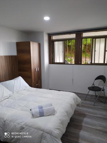 a bedroom with a white bed with a towel on it at escalinata in Manizales