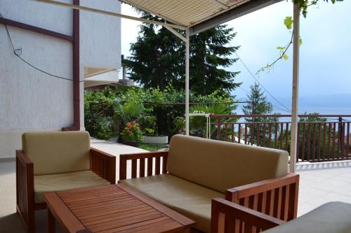 2 Stühle und ein Tisch auf einem Balkon mit Meerblick in der Unterkunft Villa Fania in Ohrid