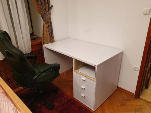 a desk and a chair in a room at Apartments Fazarinc with parking, wellness and city store in the center of Celje in Celje