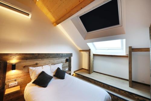 1 dormitorio con 1 cama y TV de pantalla plana en Superbe appartement, hypercentre au calme avec bain balnéo, en Gérardmer