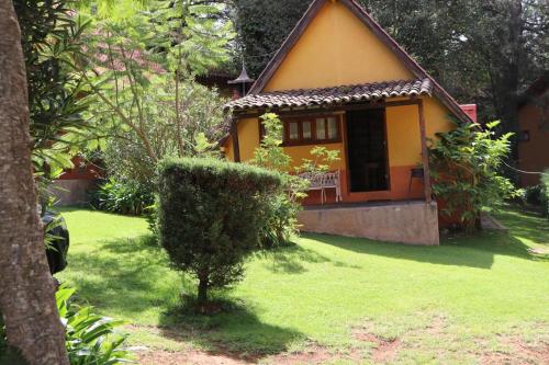 una pequeña casa amarilla con un patio verde en Cabañas Lupita 22 en Mazamitla
