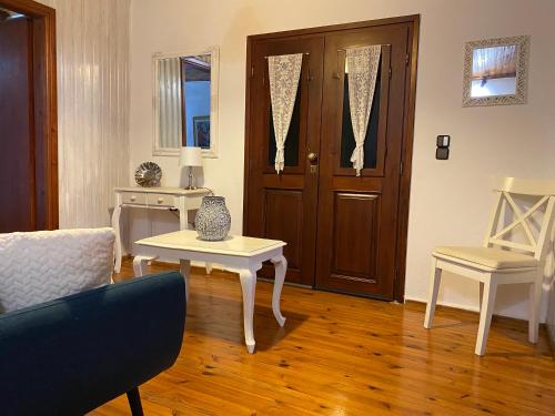 a living room with a couch and a table and a door at Sarakinas Farm House in Kalabaka