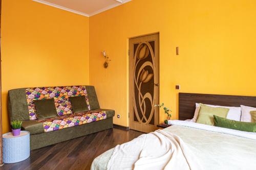 a yellow room with a couch and a bed at Апартаменты в историческом центре на Репина, 52 in Kaliningrad