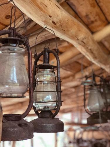 three old lanterns hanging from the ceiling of a barn at Чорногірський Вітер in Verkhovyna