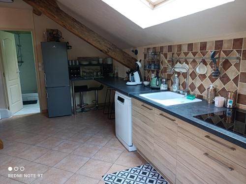 una cucina con un lavello e un piano di lavoro di Sauna & Double Jacuzzi intérieur et sous les étoiles 1h30 Paris a Ladon