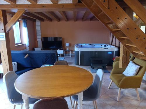 Camera con tavolo e vasca idromassaggio. di Sauna & Double Jacuzzi intérieur et sous les étoiles 1h30 Paris a Ladon