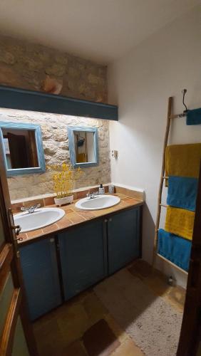 a bathroom with two sinks and two mirrors at La Charmentaise in Saint-Sulpice-de-Cognac