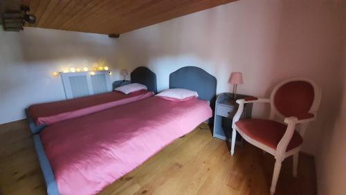 a small bedroom with two beds and a chair at La Charmentaise in Saint-Sulpice-de-Cognac