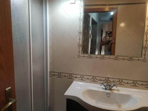 a bathroom with a sink and a mirror at Casa do Limoeiro - Casa in Golegã