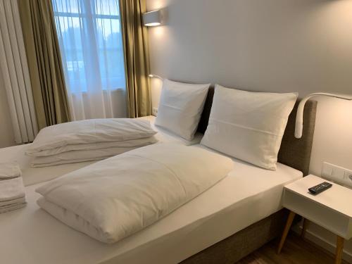 a bedroom with two beds with white pillows at Park-Lodge Am Rohrbusch in Münster