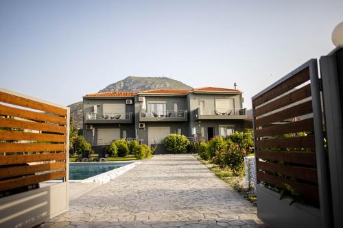 a walkway leading to a house with a pool at Isola Apartments in Xylokastro