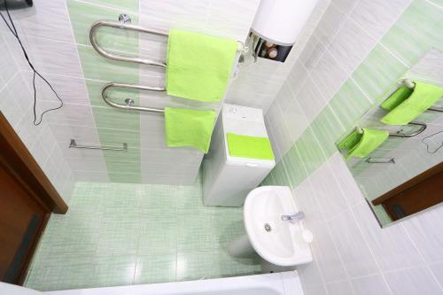 a bathroom with a sink and a toilet and green towels at flat-all 151 Kropotkina двухкомнатная квартира с 7 местами рядом с ТРЦ " Галерея Чижова" in Voronezh