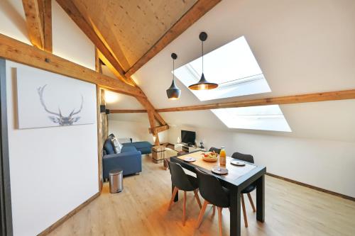 a living room with a table and chairs and a couch at Superbe appartement, hypercentre au calme avec bain balnéo in Gérardmer