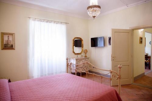 a bedroom with a pink bed and a window at Appartamento di Lusso in Borgo Storico Toscano in Bibbiena