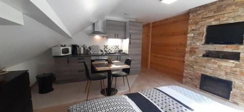1 dormitorio con cama, mesa y chimenea en Le montagnard, en Gérardmer
