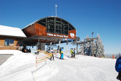 - un groupe de personnes à skis devant un lodge de ski dans l'établissement Le montagnard, à Gérardmer