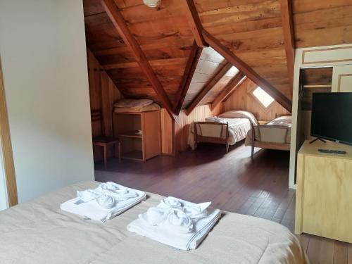 1 dormitorio con 1 cama con toallas en Wesley House en San Martín de los Andes