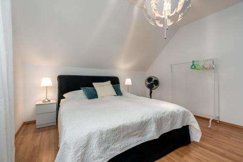 a bedroom with a white bed and a chandelier at Veens Crew Home 7 Pax in Dreieich