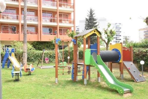 a playground in a park with slides and swings at APPART STANDING 2 chambres 2SDB clim PISCINE PARKING WIFI TERRASSE 21m2 LOCAL VELO Port-Aventura, plage, centre in Salou