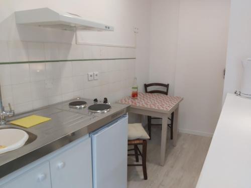 una pequeña cocina con fregadero y mesa en Studios Archange St Michel, en Lourdes