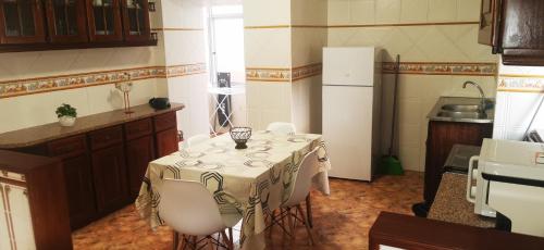 a kitchen with a table with chairs and a refrigerator at Ricky House Big Waves in Nazaré