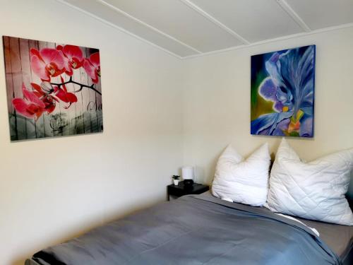 a bedroom with a bed with two paintings on the wall at Tiny House Mehring in Mehring