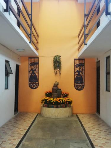 a hallway of a building with a plant on the wall at Hotel Villa Hermosa in Oaxaca City