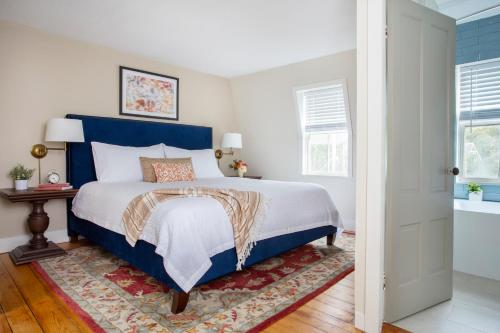 a bedroom with a blue and white bed and a rug at Chapter House in Yarmouth