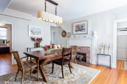 a dining room with a table and chairs and a fireplace at Chapter House in Yarmouth