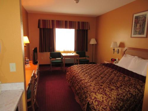 a hotel room with a bed and a desk and a window at Parkfield Inn - Warsaw in Warsaw