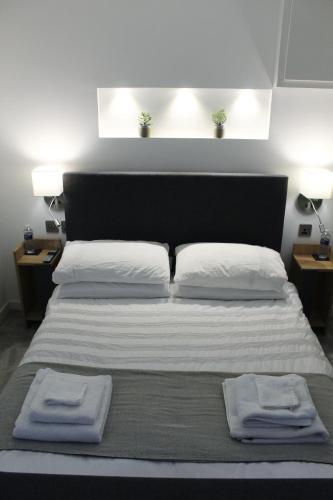 a bedroom with a bed with two towels on it at One One Five Apartment in Swansea