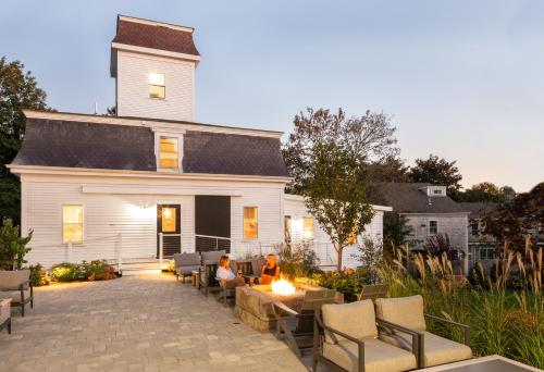 two people sitting on a patio in front of a house at Chapter House in Yarmouth